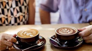 Two seniors share coffee.